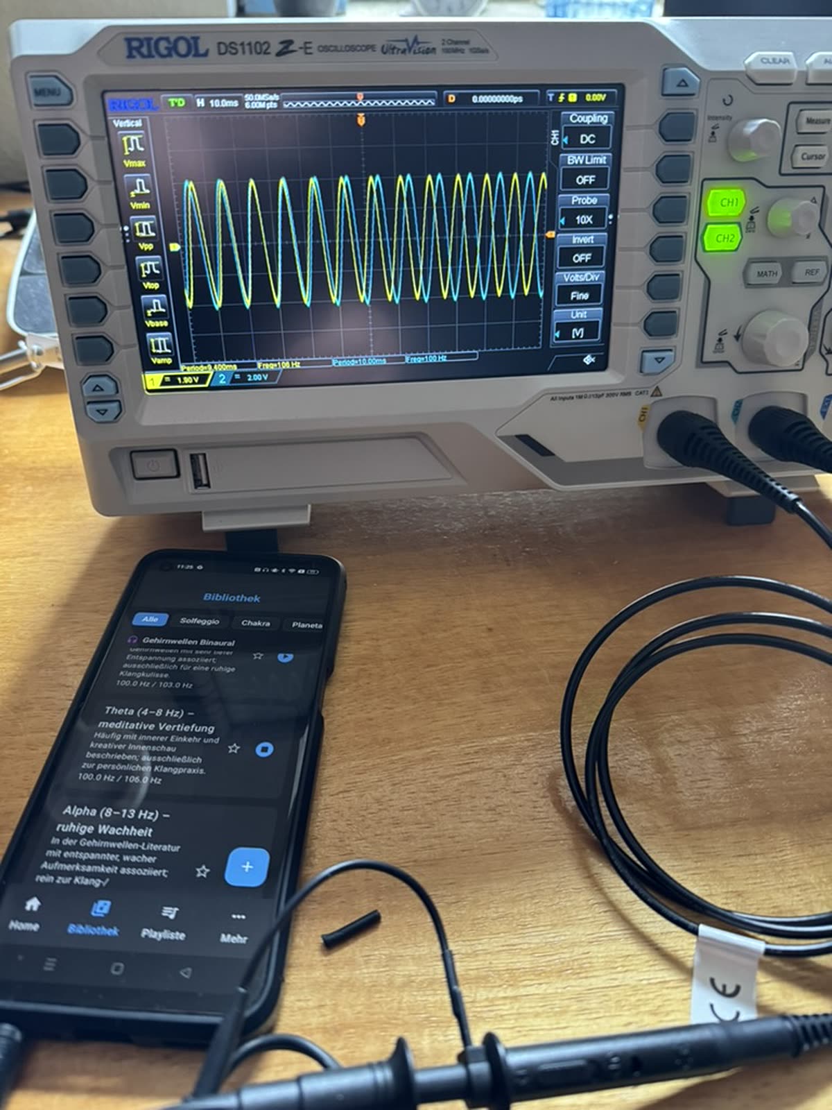 Binaural measurement: two sine waves, yellow (CH1) at 100 Hz, blue (CH2) at 106 Hz — 6 Hz difference, in the theta range