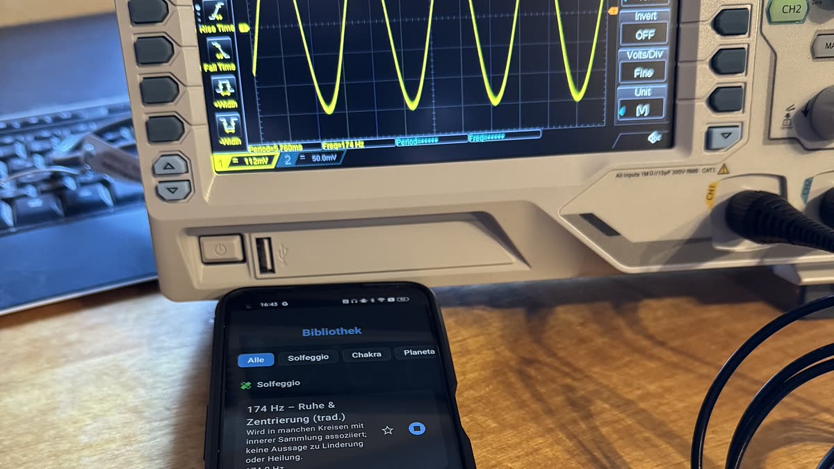 Smartphone running AuraHarmony at 174 Hz next to a Rigol oscilloscope showing the matching sine wave and frequency readout